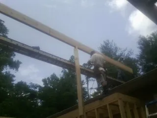 Carpenter setting a ridge beam over a new addition frame — Ice Dam Removal by Roofing Brothers in Potwin