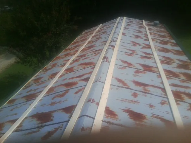 Rusted metal roof panels with new wood purlins before replacement — Storm Damage Roof Repair in Potwin by Roofing Brothers