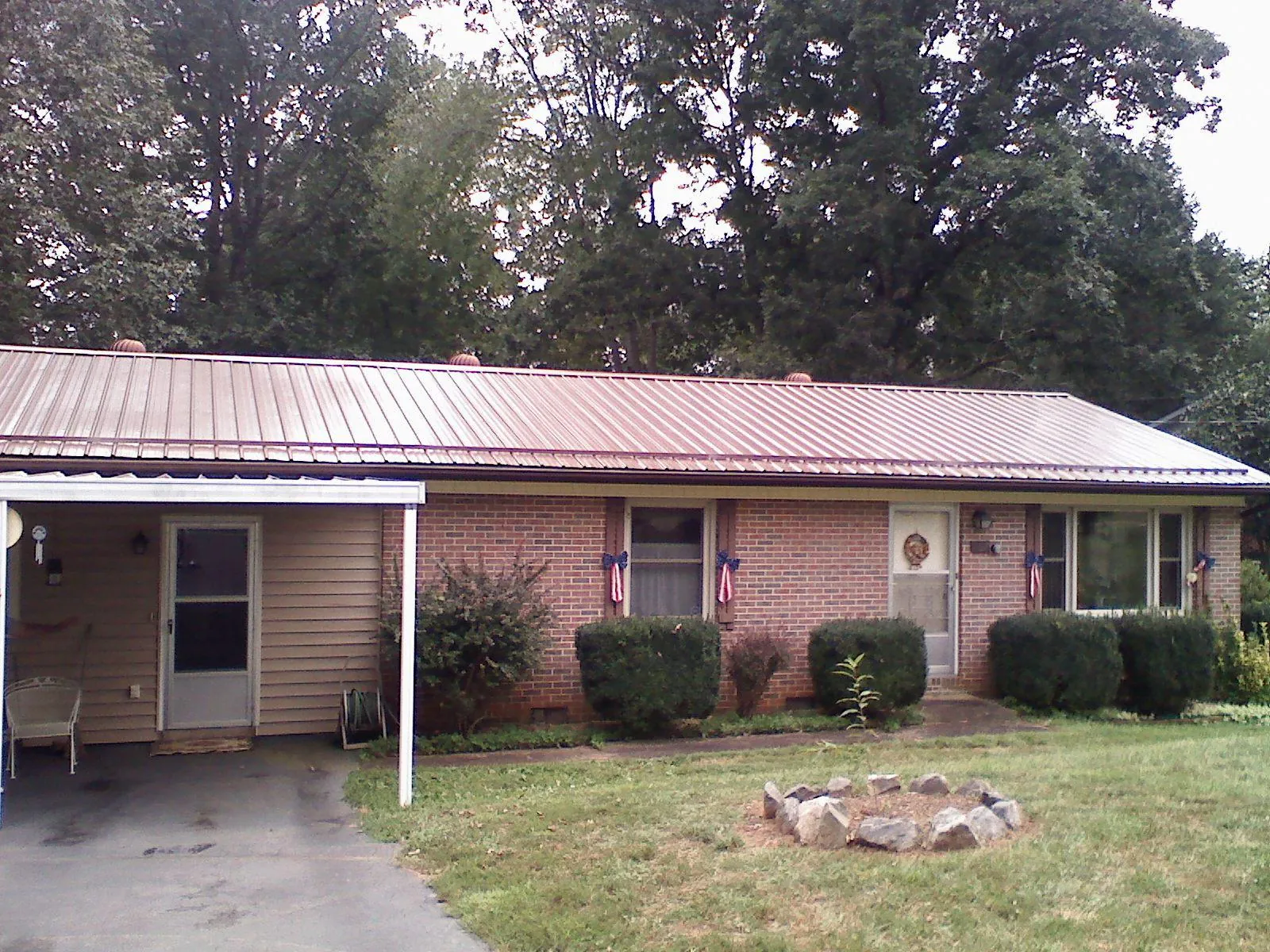 Bronze metal roof and carport on a brick ranch home — Roof Repair work by our crew in Potwin