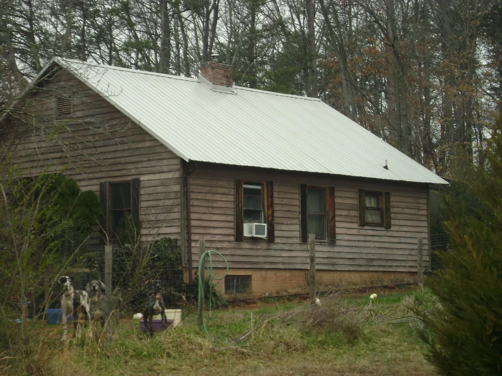 White metal roof on an old wood sided farmhouse, from a Metal Roof Installation job in Potwin